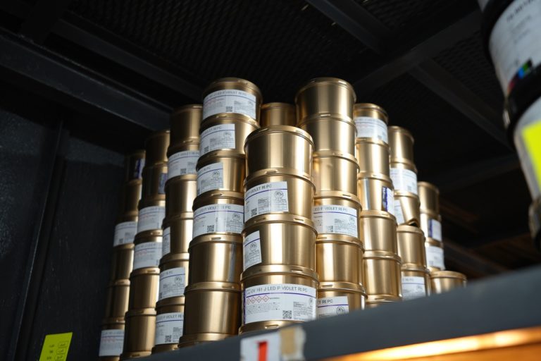 Tins of printing ink stacked on a shelf at the Etalex factory